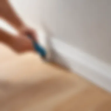 Close-up of adhesive being applied to the back of a plastic skirting board