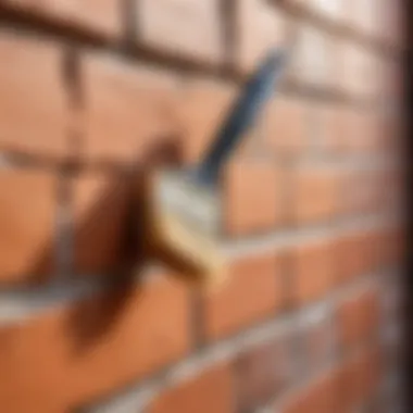 Close-up of a brush applying paint to textured brick