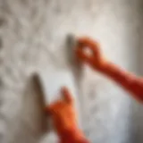 A close-up view of textured wallpaper being peeled from a wall, revealing the clean surface beneath.