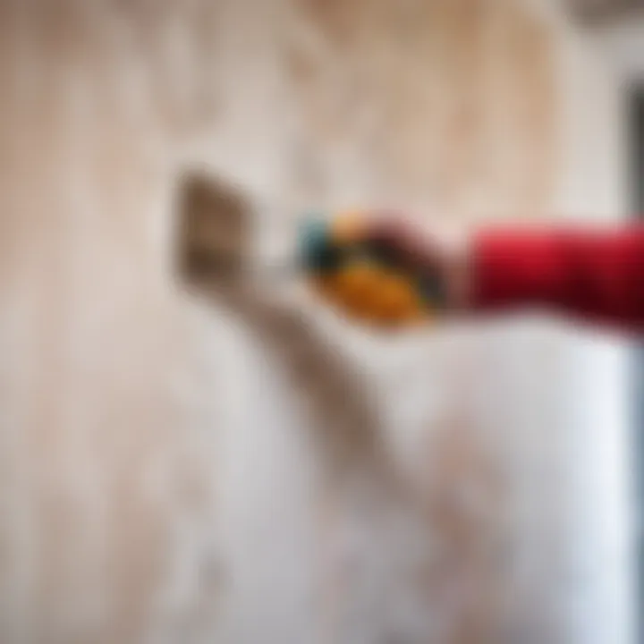 Close-up of a wall with painted wallpaper being removed