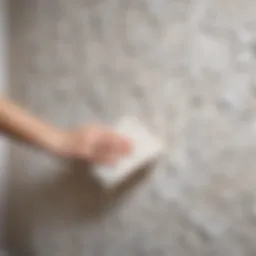 A close-up of wallpaper being peeled from a wall, showcasing the texture and paper backing.